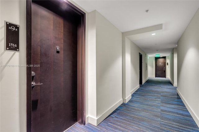 hallway featuring baseboards and carpet floors