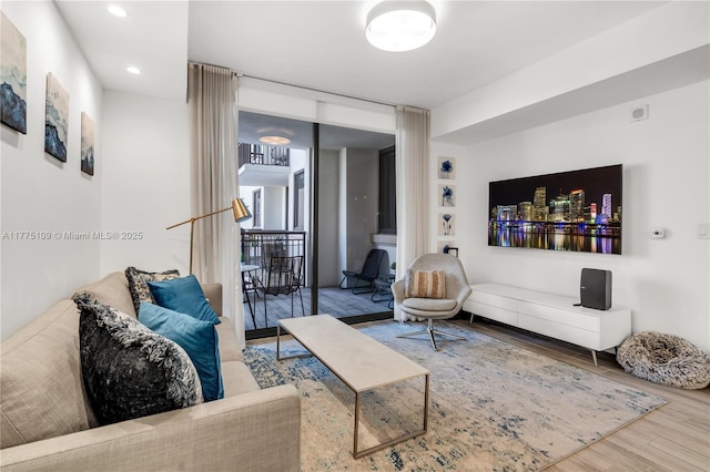 living room featuring a wall of windows, wood finished floors, and recessed lighting