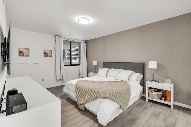 bedroom featuring baseboards and wood finished floors
