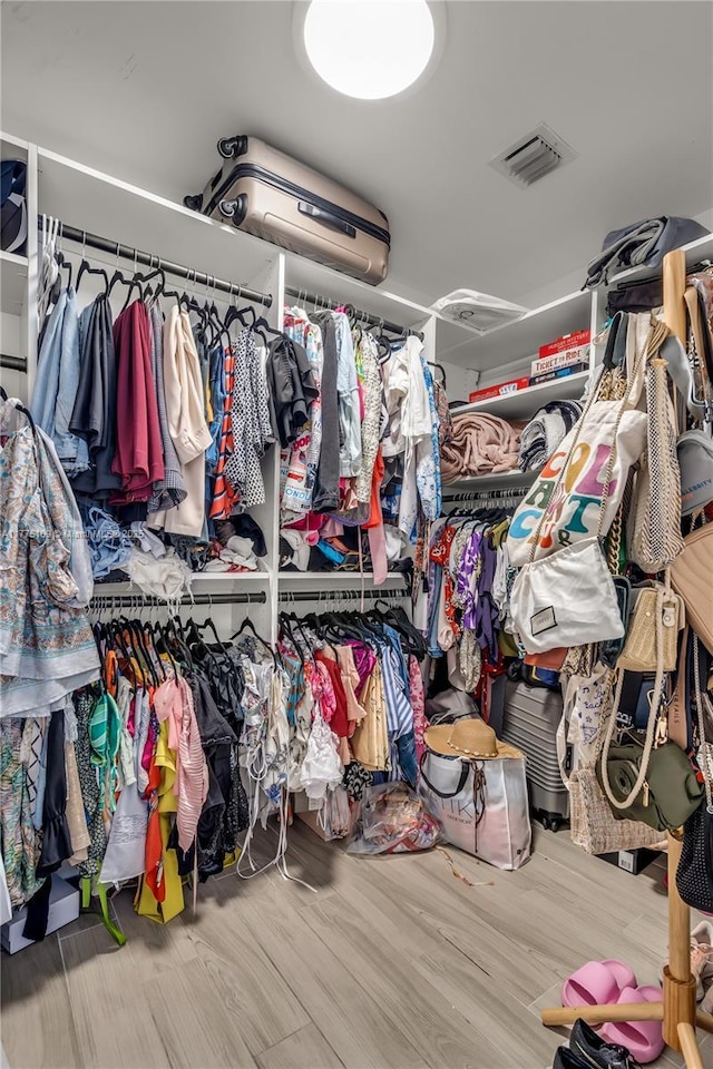 walk in closet with visible vents and wood finished floors