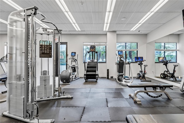 gym featuring baseboards and a drop ceiling