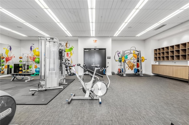 gym with baseboards and a drop ceiling