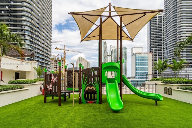 community playground with a lawn and a view of city