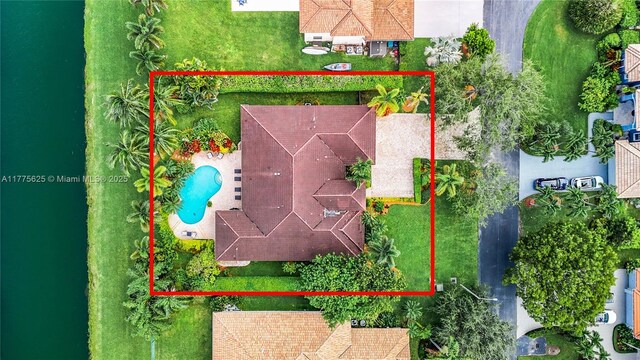 aerial view of property and surrounding area featuring property parcel outlined and a pool area