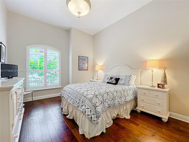 bedroom featuring dark wood-style flooring and baseboards