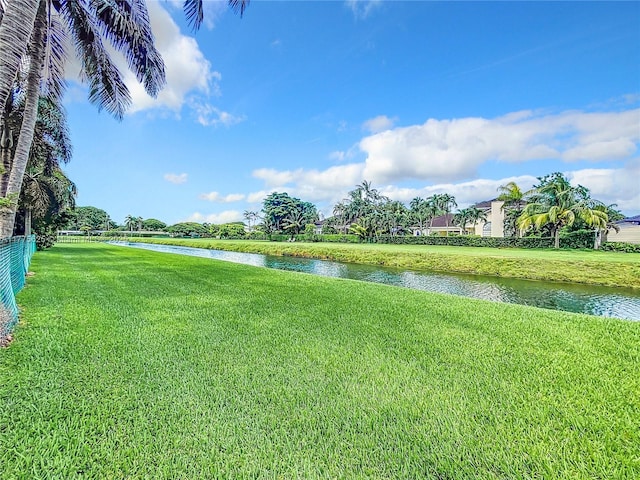 view of green lawn featuring a water view