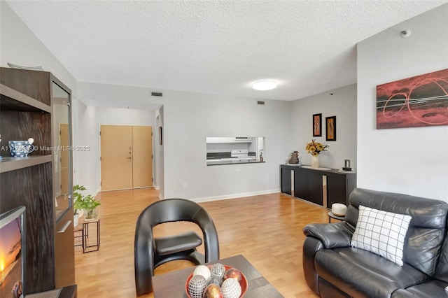 9805 NW 52nd St Unit 306, Doral, FL 33178 - living area featuring baseboards, a textured ceiling, visible vents, and light wood-type flooring