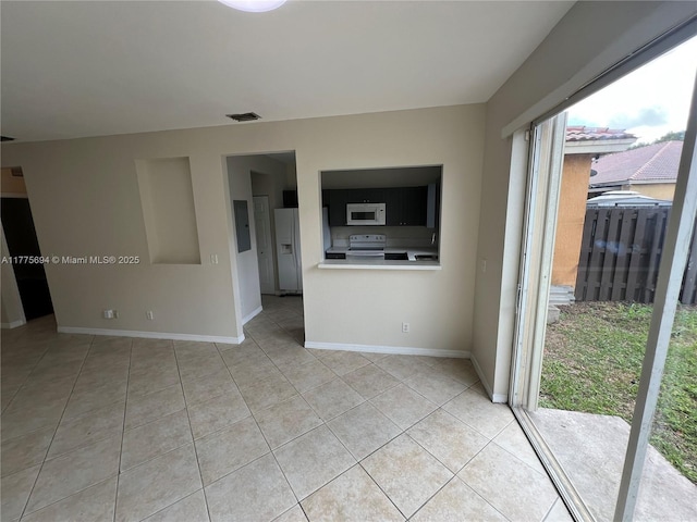100 SW 15th Ave, Homestead, FL 33030 - unfurnished living room featuring light tile patterned flooring, electric panel, and baseboards