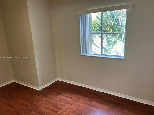 100 SW 15th Ave, Homestead, FL 33030 - empty room with healthy amount of natural light, dark wood-style flooring, and baseboards