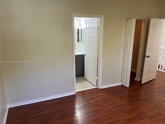 100 SW 15th Ave, Homestead, FL 33030 - unfurnished bedroom with wood finished floors, baseboards, and ensuite bathroom