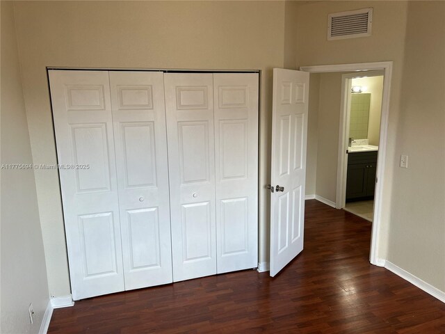 100 SW 15th Ave, Homestead, FL 33030 - unfurnished bedroom with dark wood finished floors, baseboards, and a closet