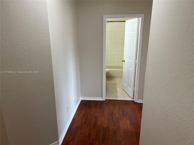 100 SW 15th Ave, Homestead, FL 33030 - hallway featuring a textured wall, wood finished floors, and baseboards