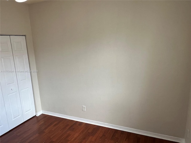 100 SW 15th Ave, Homestead, FL 33030 - unfurnished bedroom with dark wood finished floors, baseboards, and a closet