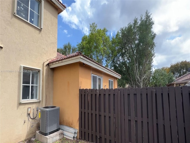 100 SW 15th Ave, Homestead, FL 33030 - view of side of property with central AC unit, stucco siding, and fence