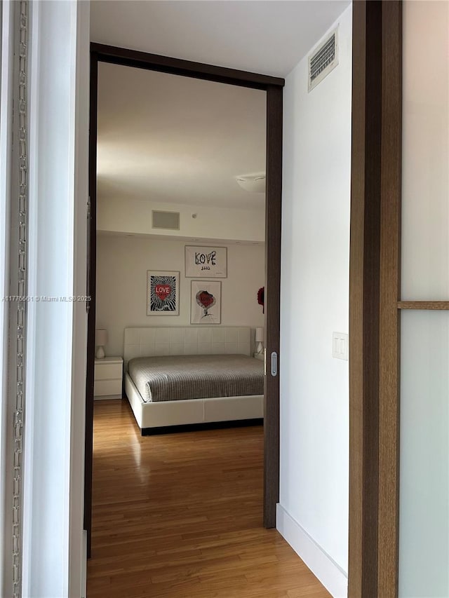 hallway with visible vents and wood finished floors