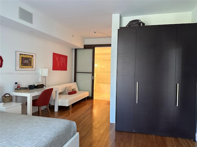 bedroom with visible vents and wood finished floors