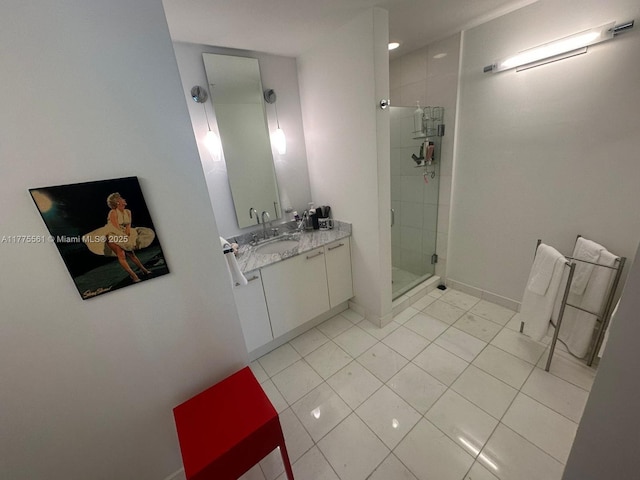 bathroom with vanity, baseboards, tile patterned floors, and a shower stall
