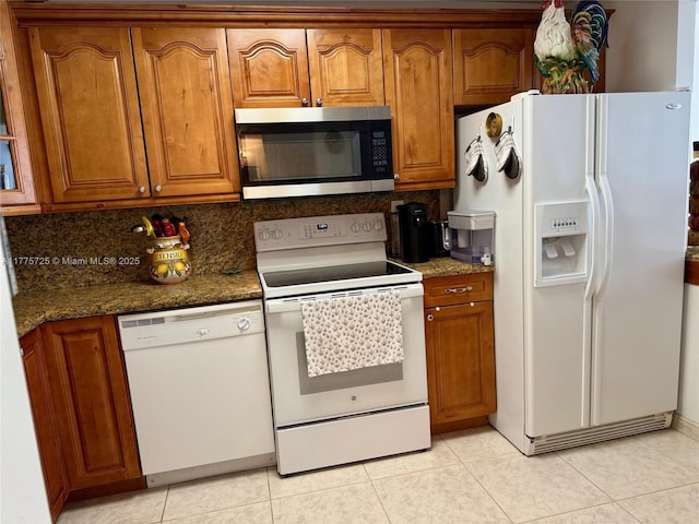 1901 Brickell Ave Unit B804, Miami, FL 33129 - kitchen with brown cabinetry, decorative backsplash, light tile patterned floors, and white appliances