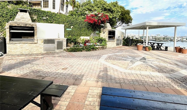 1901 Brickell Ave Unit B804, Miami, FL 33129 - view of patio / terrace with a fireplace, an outdoor kitchen, and a water view