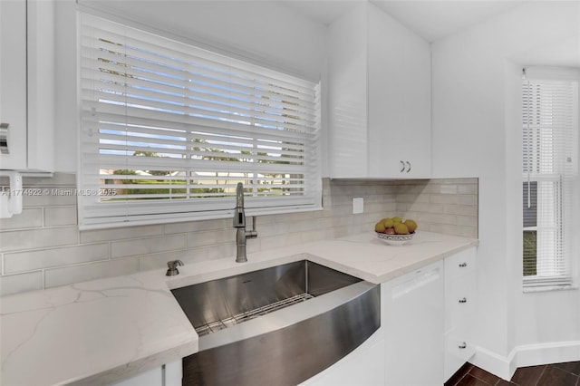 kitchen featuring a sink, white cabinets, and backsplash