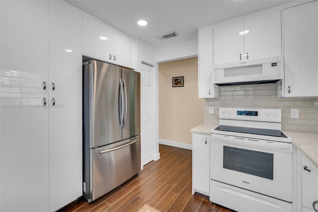 kitchen with white appliances, dark wood finished floors, decorative backsplash, white cabinetry, and recessed lighting