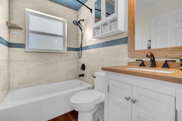full bath with toilet, wood finished floors, bathtub / shower combination, tile walls, and vanity