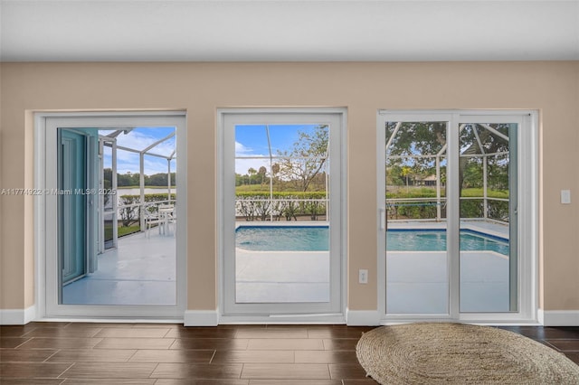 doorway with baseboards and wood finish floors