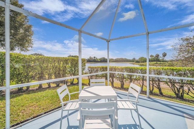 sunroom / solarium with a water view and outdoor dining space
