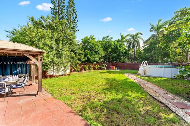 view of yard with a fenced backyard, a gazebo, a patio, and a fenced in pool