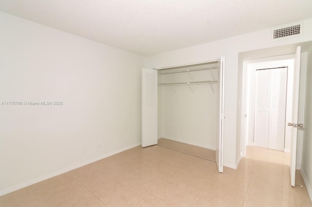 447 NE 195th St Unit 217, Miami, FL 33179 - unfurnished bedroom featuring a closet, baseboards, and light tile patterned flooring