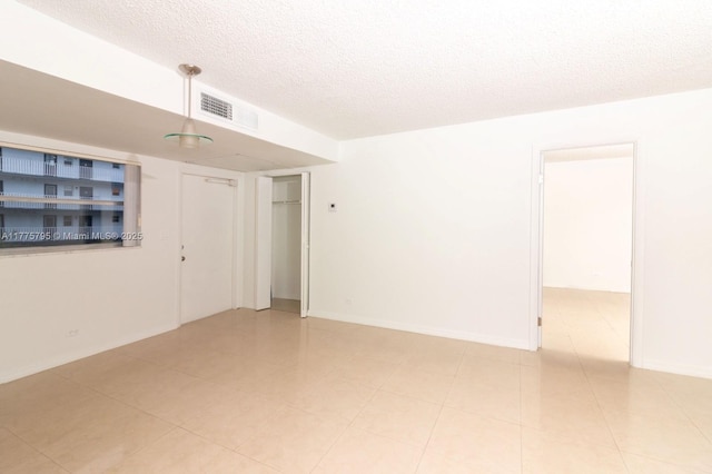 447 NE 195th St Unit 217, Miami, FL 33179 - empty room featuring a textured ceiling and baseboards