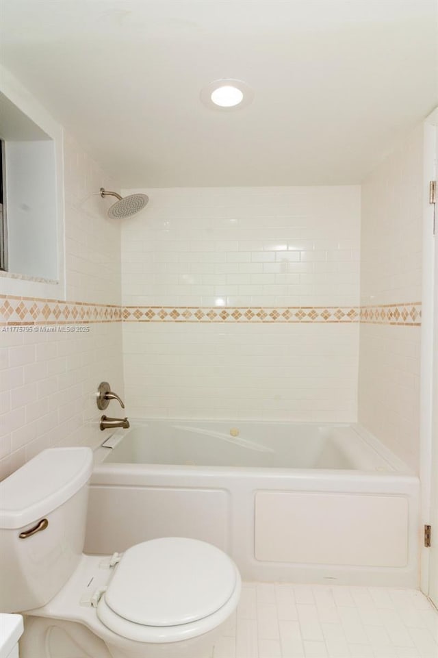 447 NE 195th St Unit 217, Miami, FL 33179 - bathroom with toilet, tile walls, washtub / shower combination, and tile patterned flooring