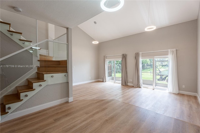 4291 S Pine Island Rd, Davie, FL 33328 - unfurnished living room featuring wood finished floors, stairs, and high vaulted ceiling