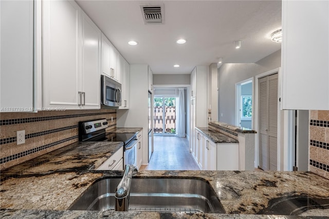 4291 S Pine Island Rd, Davie, FL 33328 - kitchen featuring appliances with stainless steel finishes, dark stone countertops, white cabinets, decorative backsplash, and recessed lighting