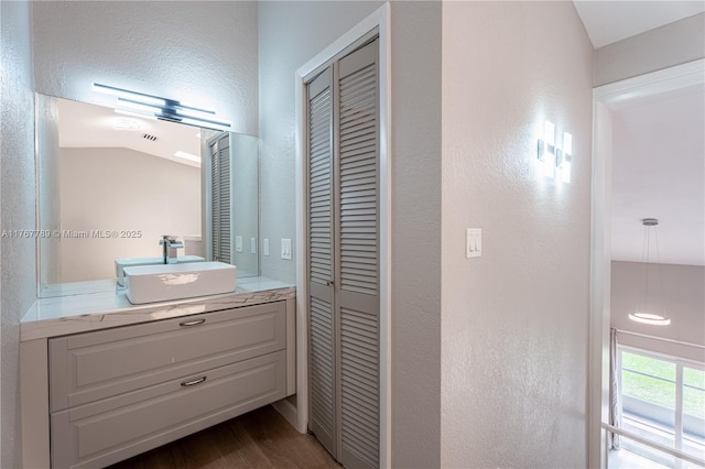 4291 S Pine Island Rd, Davie, FL 33328 - bathroom with a closet, vanity, a textured wall, wood finished floors, and lofted ceiling