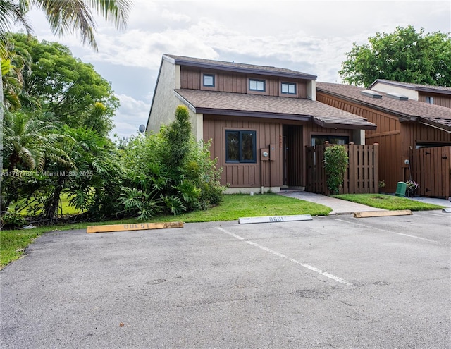 4291 S Pine Island Rd, Davie, FL 33328 - view of front of house featuring uncovered parking, board and batten siding, roof with shingles, and a gate