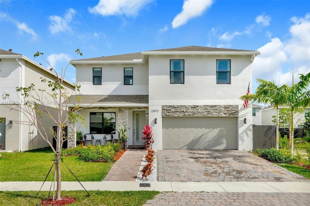 12973SW 266th Ter, Homestead, FL 33032 - view of front of house featuring stucco siding, stone siding, driveway, a garage, and a porch