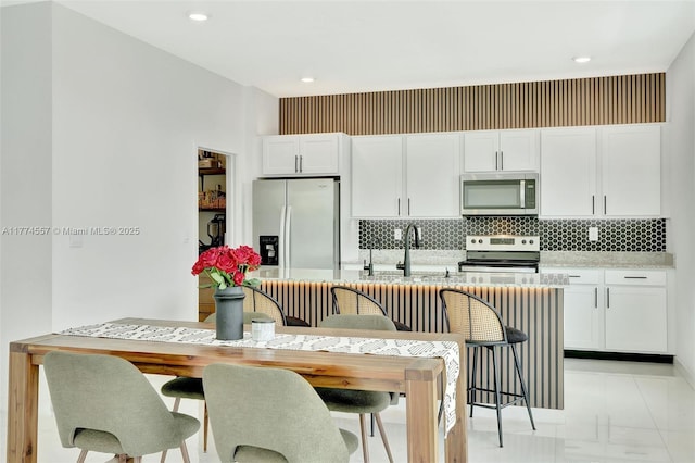 12973SW 266th Ter, Homestead, FL 33032 - kitchen with appliances with stainless steel finishes, tasteful backsplash, white cabinets, light countertops, and a sink