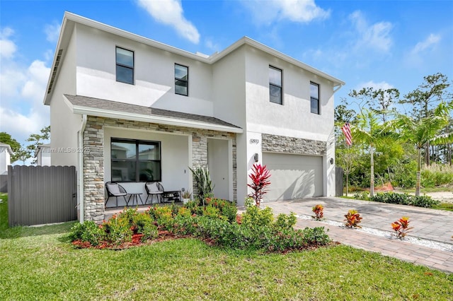 12973SW 266th Ter, Homestead, FL 33032 - view of front of home featuring stone siding, a porch, a garage, and stucco siding
