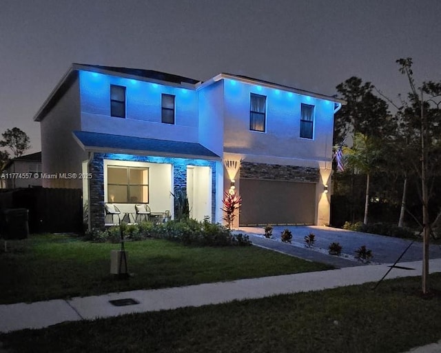 12973SW 266th Ter, Homestead, FL 33032 - view of front of house with stone siding, an attached garage, stucco siding, driveway, and a lawn