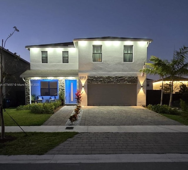 12973SW 266th Ter, Homestead, FL 33032 - view of front of property with decorative driveway, stucco siding, an attached garage, and stone siding