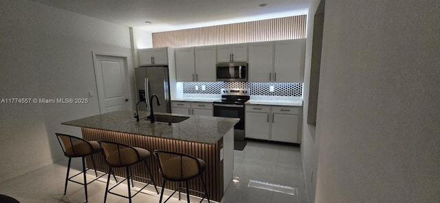 12973SW 266th Ter, Homestead, FL 33032 - kitchen with stainless steel appliances, backsplash, a sink, a breakfast bar area, and a kitchen island with sink