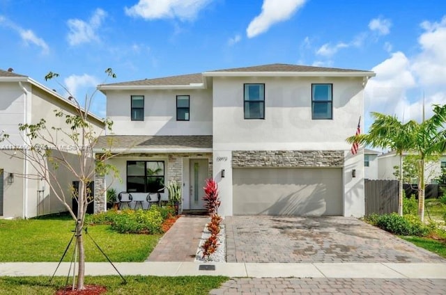 12973SW 266th Ter, Homestead, FL 33032 - view of front facade with stucco siding, a garage, decorative driveway, stone siding, and a porch