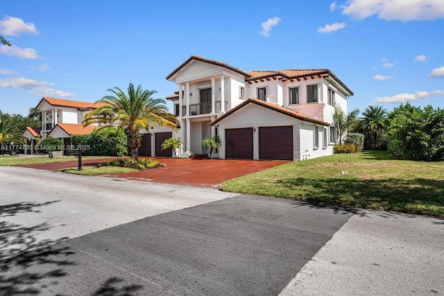 7767 SW 188th St, Cutler Bay, FL 33157 - mediterranean / spanish-style home featuring a balcony, a tile roof, decorative driveway, a front yard, and stucco siding