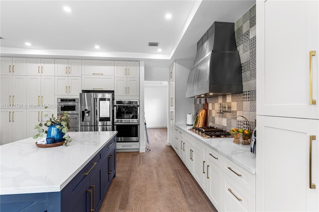 7767 SW 188th St, Cutler Bay, FL 33157 - kitchen featuring blue cabinets, appliances with stainless steel finishes, custom exhaust hood, recessed lighting, and backsplash