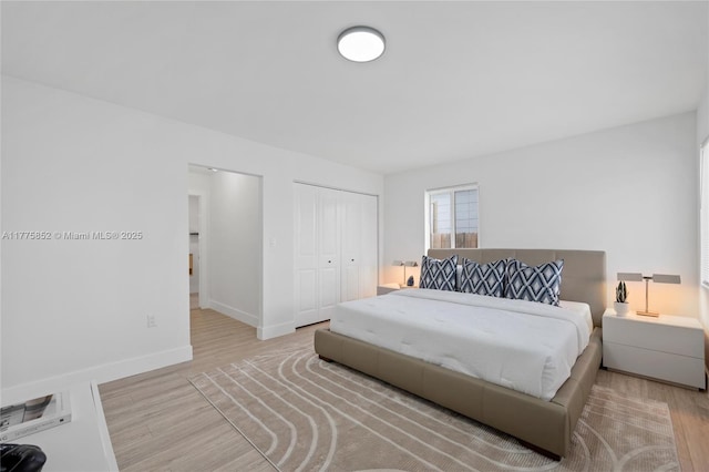 bedroom featuring baseboards, wood finished floors, and a closet
