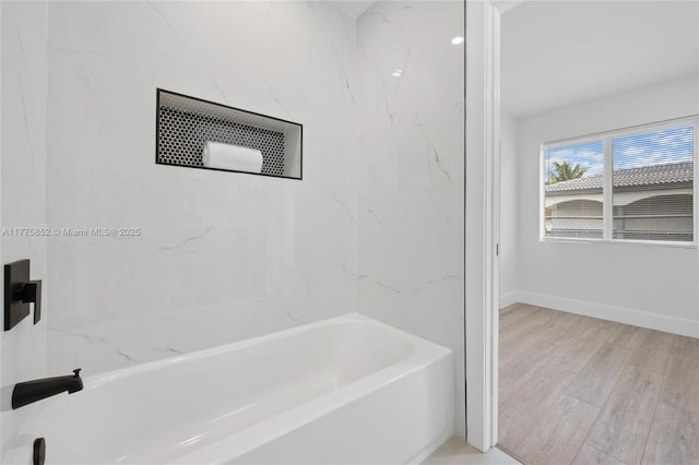 full bath featuring wood finished floors and baseboards