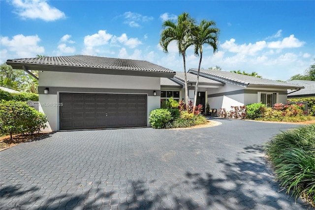 9030 SW 92nd Ct, Miami, FL 33176 - view of front facade with decorative driveway, a tiled roof, stucco siding, and a garage