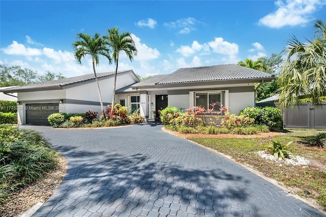 9030 SW 92nd Ct, Miami, FL 33176 - view of front of house featuring a tiled roof, decorative driveway, a garage, and stucco siding