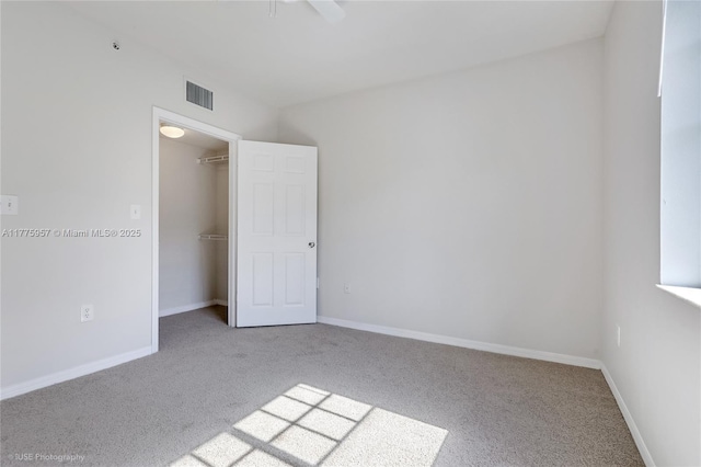 6434 Emerald Dunes Dr Unit 202, West Palm Beach, FL 33411 - unfurnished bedroom featuring carpet flooring, a walk in closet, baseboards, visible vents, and a closet